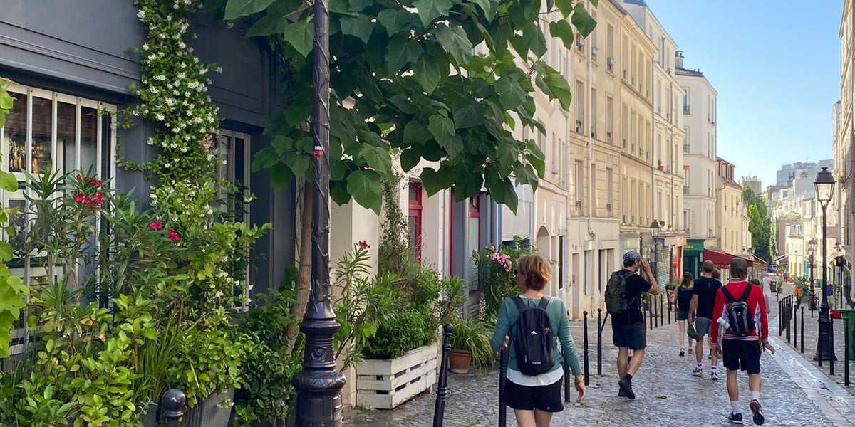 Groupe de marcheurs dans une ruelle d'ancien village parisien